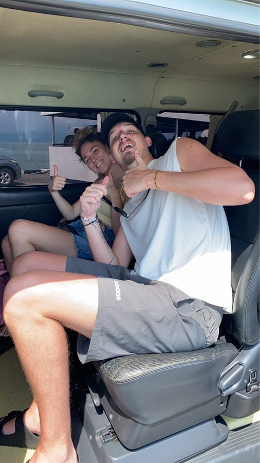 Two guests giving a thumbs up from the rear seats of a WayGo VIP van.