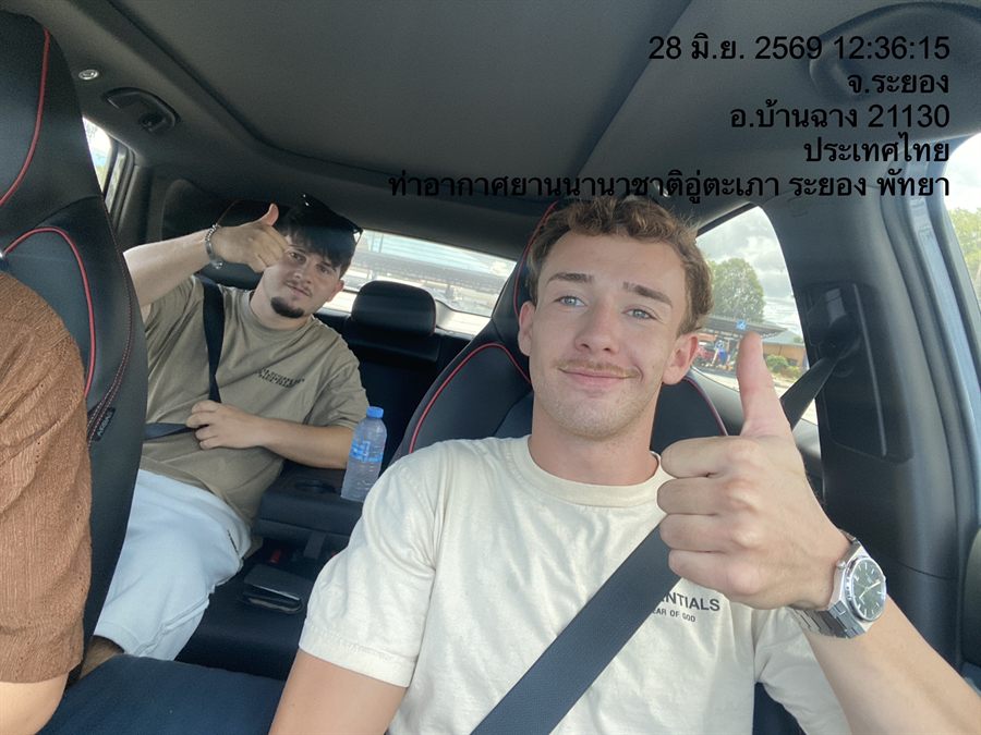 Two young travellers giving a thumbs up in a WayGo car at U-Tapao Airport, Ban Chang.